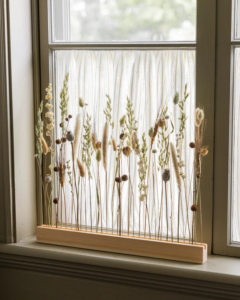Blomlist i furu med torkade blommor i grönt och vitt